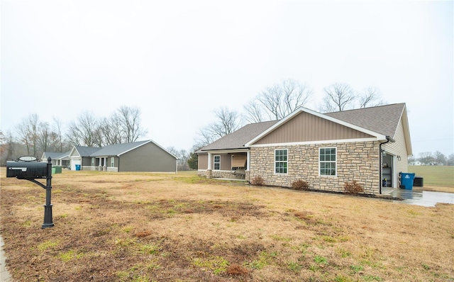 12 Paradise St, Benton, MO 63736 - view of front of property with stone siding, a front lawn, board and batten siding, and a shingled roof