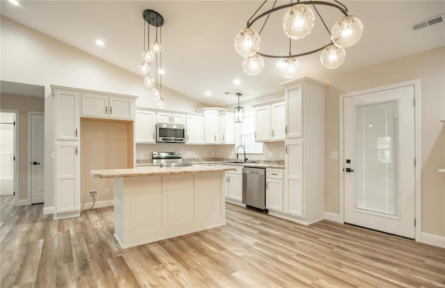 12 Paradise St, Benton, MO 63736 - kitchen with stainless steel appliances, a sink, lofted ceiling, light wood-style floors, and white cabinets