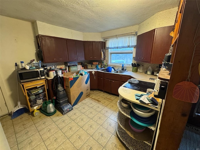 1000 White St, Canton, MO 63435 - kitchen featuring stainless steel microwave, light countertops, a textured ceiling, and a sink