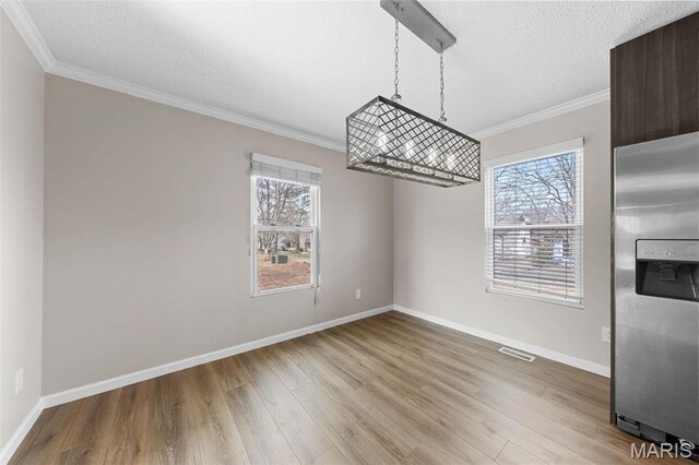 655 Lakewood Dr, Lake St Louis, MO 63367 - unfurnished dining area featuring plenty of natural light, crown molding, wood finished floors, a textured ceiling, and baseboards