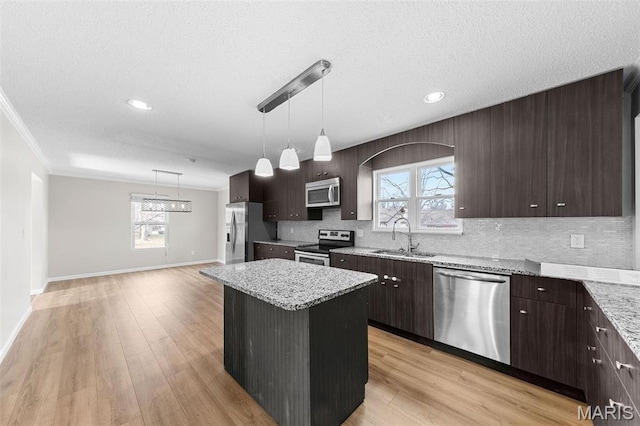 655 Lakewood Dr, Lake St Louis, MO 63367 - kitchen featuring stainless steel appliances, a sink, dark brown cabinetry, tasteful backsplash, and a kitchen island