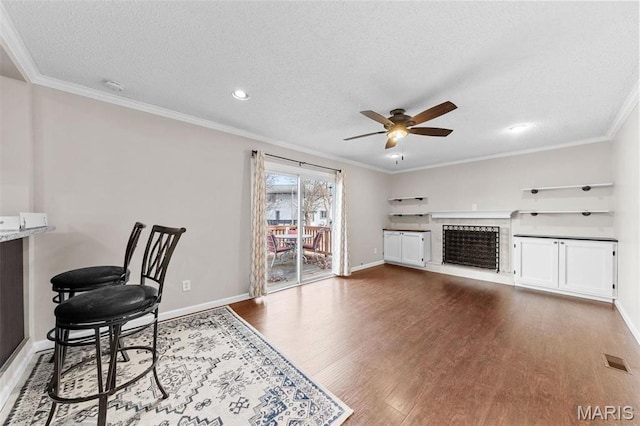 655 Lakewood Dr, Lake St Louis, MO 63367 - office area featuring ceiling fan, wood finished floors, a textured ceiling, a fireplace with raised hearth, and crown molding