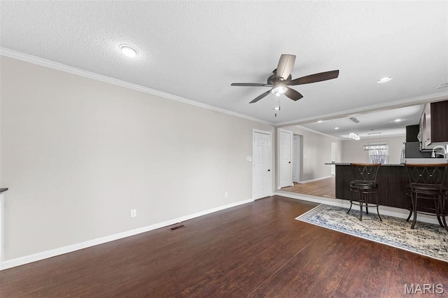 655 Lakewood Dr, Lake St Louis, MO 63367 - living area with dark wood-style flooring, baseboards, a ceiling fan, crown molding, and a textured ceiling