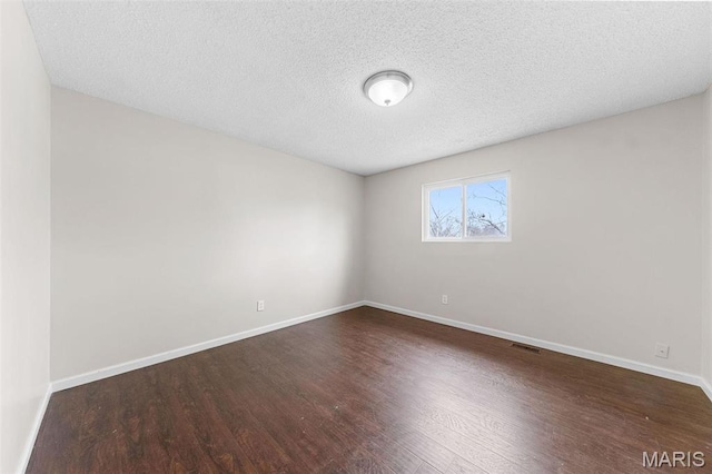 655 Lakewood Dr, Lake St Louis, MO 63367 - empty room featuring dark wood-style floors, baseboards, and a textured ceiling