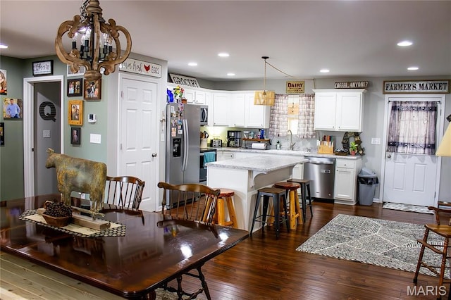 1303 W Coffman St, Salem, MO 65560 - kitchen with appliances with stainless steel finishes, white cabinetry, a chandelier, a center island, and dark wood-type flooring