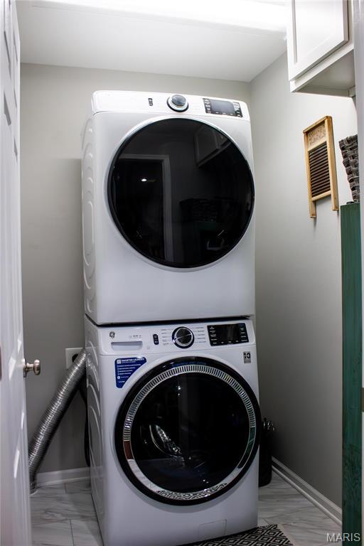 1303 W Coffman St, Salem, MO 65560 - laundry area featuring estacked washer and dryer, cabinet space, and baseboards
