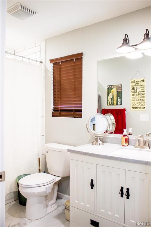 1303 W Coffman St, Salem, MO 65560 - bathroom featuring toilet, vanity, marble look tiles, and curtained shower
