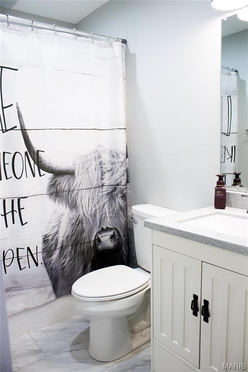 1303 W Coffman St, Salem, MO 65560 - full bath featuring marble look tile flooring, toilet, vanity, and curtained shower