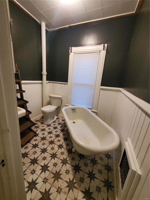 508 S Grand Ave, Houston, MO 65483 - full bath featuring tile patterned floors, a soaking tub, wainscoting, and toilet