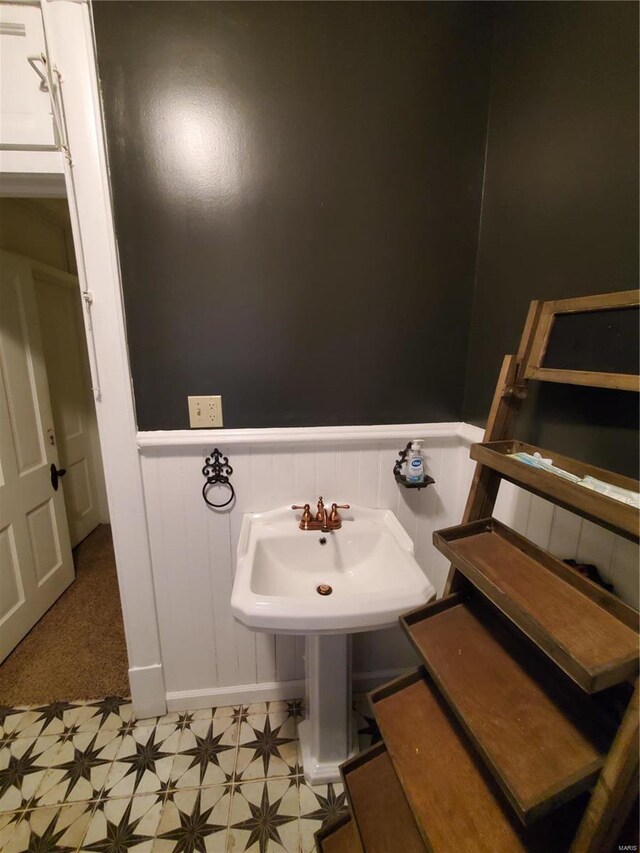 508 S Grand Ave, Houston, MO 65483 - bathroom featuring tile patterned floors, a wainscoted wall, a decorative wall, and a sink
