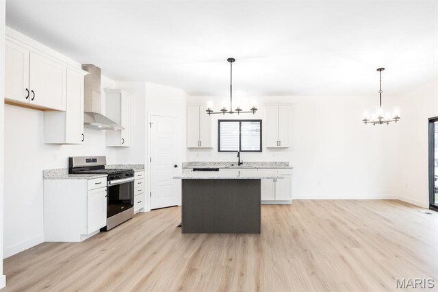 108 Chickasaw Ln, Ofallon, IL 62269 - kitchen featuring stainless steel range with gas cooktop, a chandelier, wall chimney range hood, a sink, and light wood finished floors