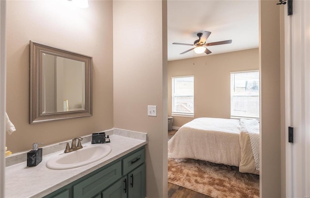 21779 Lomax Dr, Waynesville, MO 65583 - bathroom featuring vanity, connected bathroom, wood finished floors, and ceiling fan