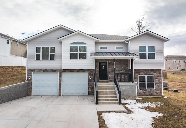 21779 Lomax Dr, Waynesville, MO 65583 - view of front facade with stone siding, a standing seam roof, driveway, an attached garage, and metal roof