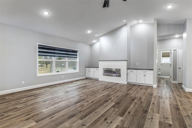 725 Deerfield Ln, Farmington, MO 63640 - unfurnished living room with vaulted ceiling, wood finished floors, a ceiling fan, baseboards, and a glass covered fireplace