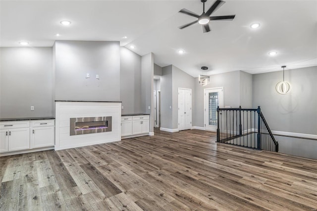 725 Deerfield Ln, Farmington, MO 63640 - unfurnished living room featuring lofted ceiling, wood finished floors, ceiling fan, recessed lighting, and a glass covered fireplace