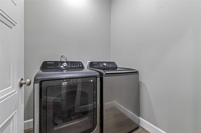 725 Deerfield Ln, Farmington, MO 63640 - laundry area featuring washer and dryer, wood finished floors, and baseboards