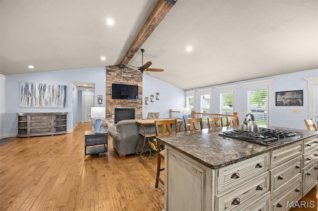2016 Richview Dr, Saint Jacob, IL 62281 - kitchen with gas cooktop, a ceiling fan, a stone fireplace, light wood finished floors, and a breakfast bar