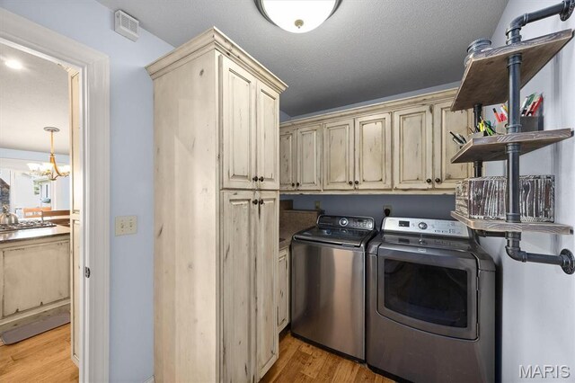2016 Richview Dr, Saint Jacob, IL 62281 - laundry room with washer and dryer, cabinet space, light wood-type flooring, and a chandelier