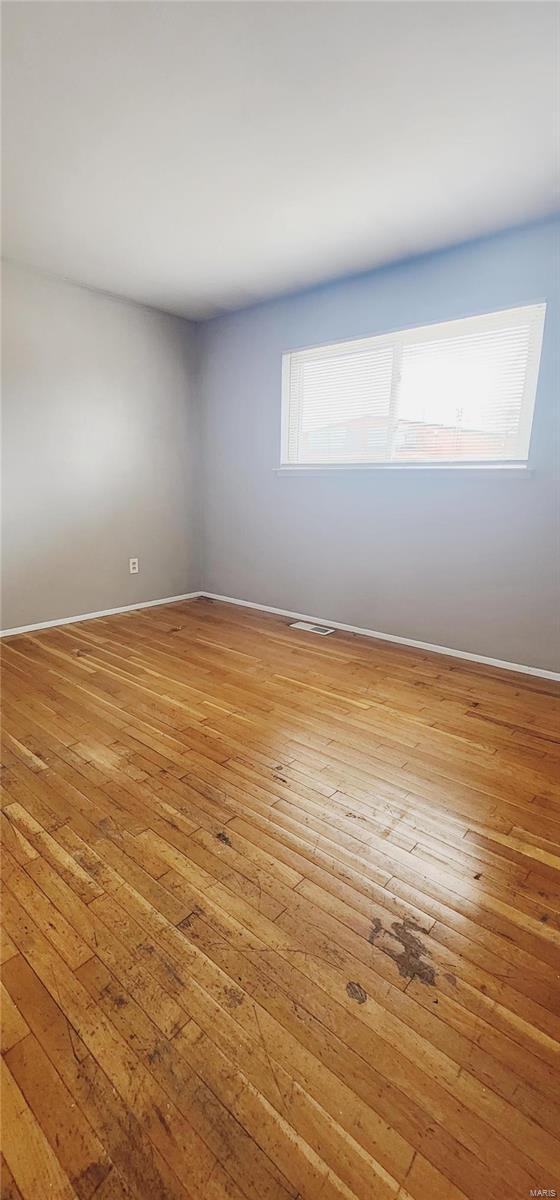 10417 Tanner Dr, Saint Louis, MO 63136 - spare room featuring wood-type flooring and baseboards