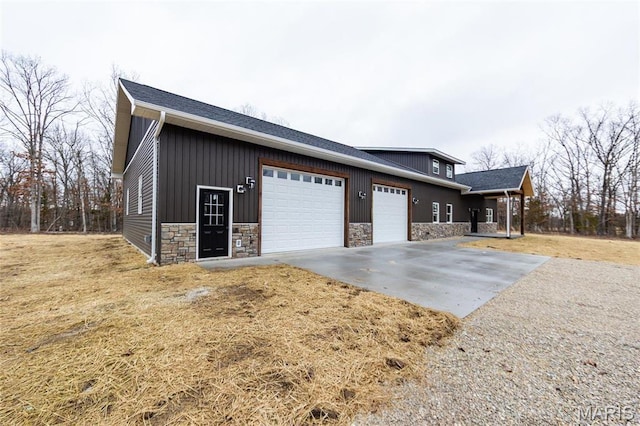 20167 County Road 7300, Newburg, MO 65560 - view of home's exterior with stone siding, an attached garage, concrete driveway, board and batten siding, and a lawn