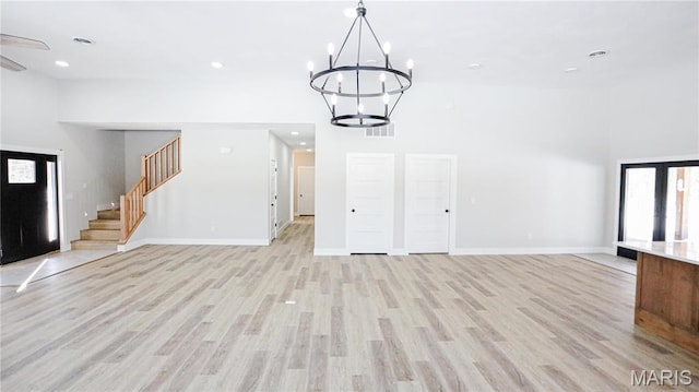 20167 County Road 7300, Newburg, MO 65560 - unfurnished living room with a towering ceiling, a chandelier, light wood-type flooring, stairs, and baseboards