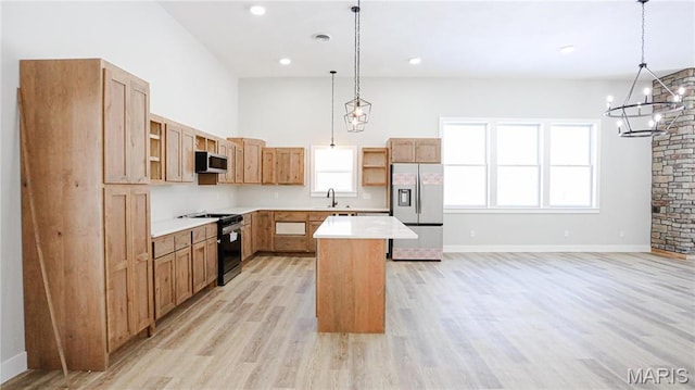 20167 County Road 7300, Newburg, MO 65560 - kitchen featuring stainless steel appliances, a center island, a sink, hanging light fixtures, and light wood-style flooring