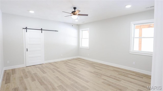 20167 County Road 7300, Newburg, MO 65560 - spare room featuring a barn door, a ceiling fan, light wood-type flooring, baseboards, and recessed lighting