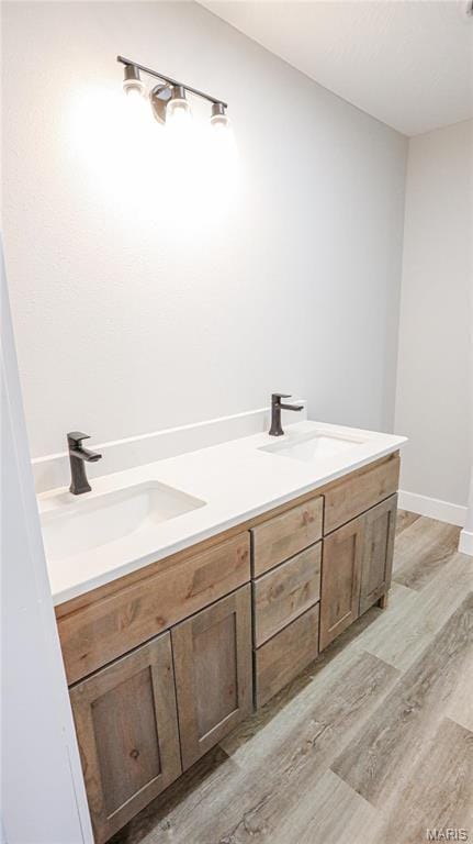 20167 County Road 7300, Newburg, MO 65560 - bathroom featuring double vanity, wood finished floors, and baseboards