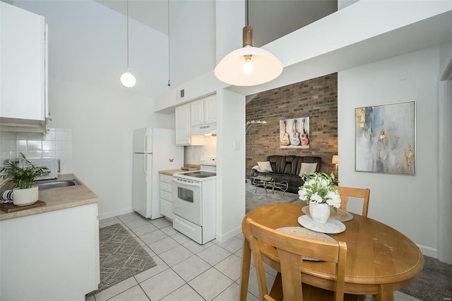 632 Coeur De Royale Dr Unit C, Saint Louis, MO 63141 - kitchen featuring white appliances, white cabinetry, light tile patterned flooring, under cabinet range hood, and baseboards
