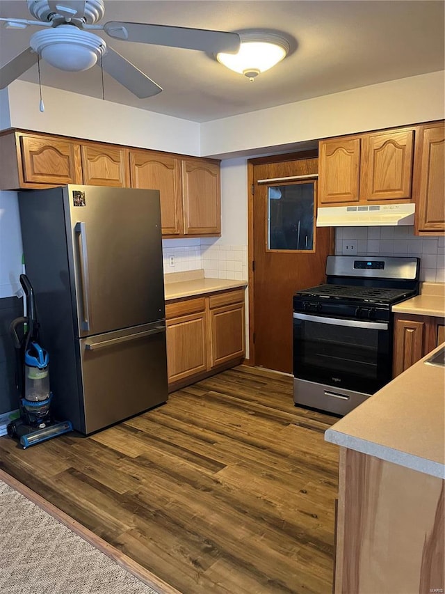 kitchen with stainless steel appliances, under cabinet range hood, ceiling fan, and decorative backsplash