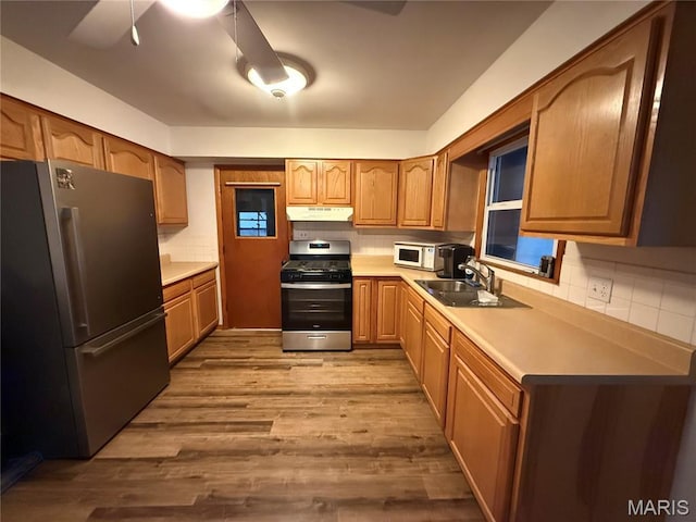 15 W Bibb Dr, Bowling Green, MO 63334 - kitchen with appliances with stainless steel finishes, under cabinet range hood, a sink, and tasteful backsplash