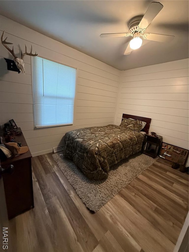 15 W Bibb Dr, Bowling Green, MO 63334 - bedroom featuring wood finished floors, wooden walls, and ceiling fan