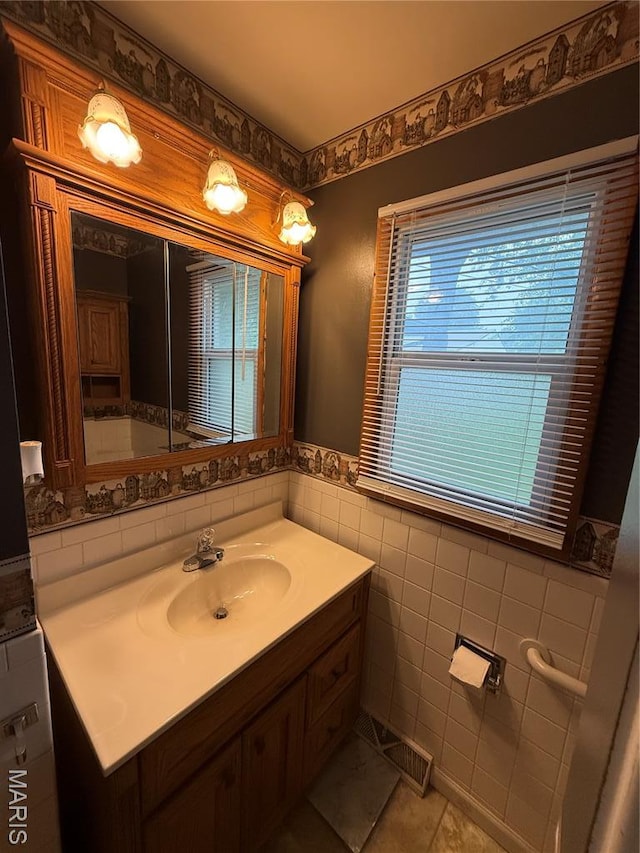 15 W Bibb Dr, Bowling Green, MO 63334 - bathroom featuring vanity, tile walls, tile patterned flooring, and a wainscoted wall