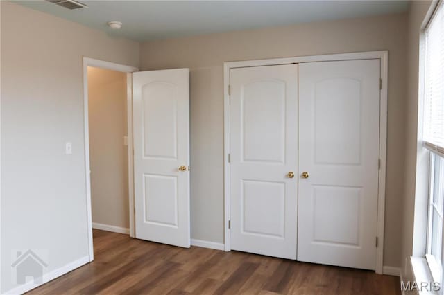 20981 Lacombe Rd, Waynesville, MO 65583 - unfurnished bedroom with wood finished floors, multiple windows, and a closet