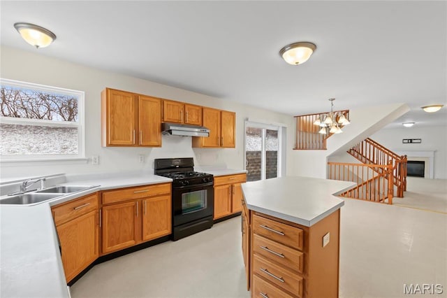 1 Ashbury Crossing Ct, Florissant, MO 63034 - kitchen with black range with gas cooktop, under cabinet range hood, a sink, a chandelier, and light countertops