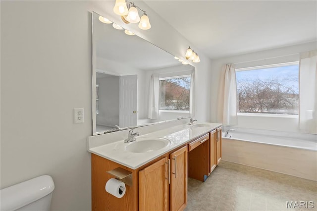 1 Ashbury Crossing Ct, Florissant, MO 63034 - bathroom featuring toilet, double vanity, and a garden tub