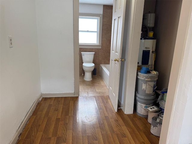 1355 Springfield Rd, Lebanon, MO 65536 - full bath with electric water heater, toilet, wood finished floors, a tub, and baseboards