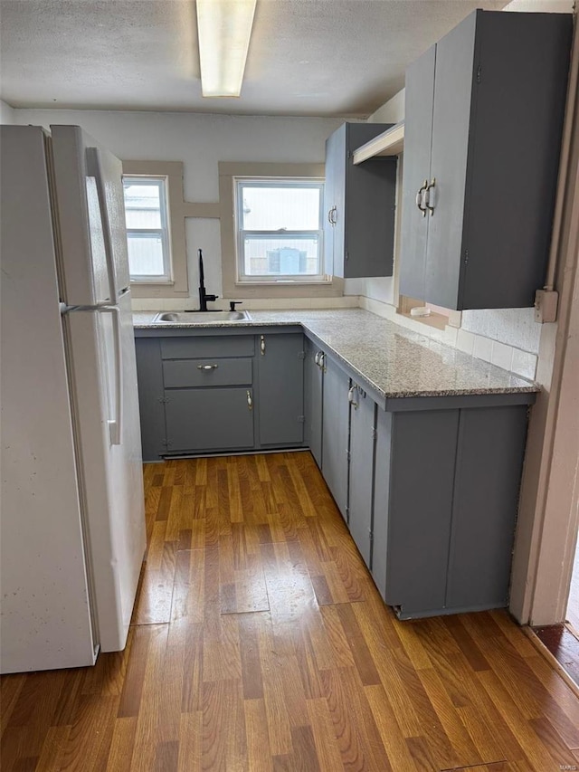 1355 Springfield Rd, Lebanon, MO 65536 - kitchen featuring freestanding refrigerator, gray cabinets, a sink, wood finished floors, and a textured ceiling