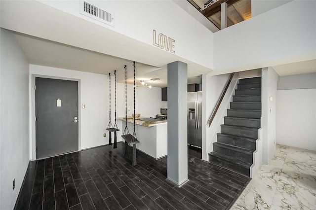 1523 S 10th St Unit 207, Saint Louis, MO 63101 - basement with stainless steel fridge with ice dispenser, stairway, and dark wood-style flooring