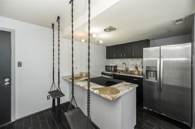 1523 S 10th St Unit 207, Saint Louis, MO 63101 - kitchen featuring stainless steel appliances, dark cabinetry, wood finish floors, light countertops, and tasteful backsplash