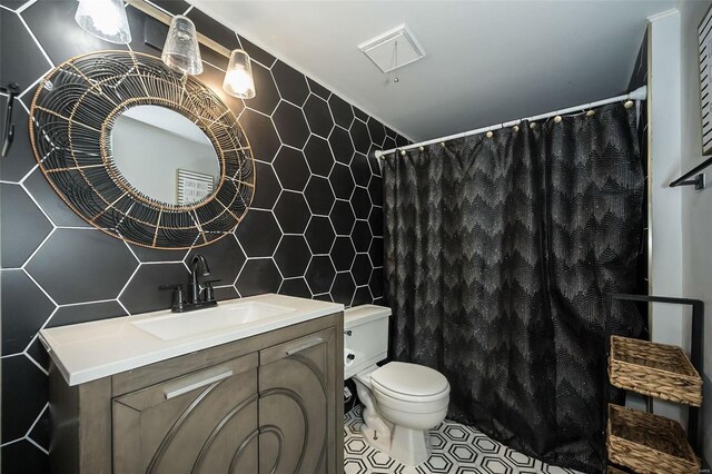1523 S 10th St Unit 207, Saint Louis, MO 63101 - full bathroom with tile walls, toilet, vanity, tasteful backsplash, and a shower with shower curtain