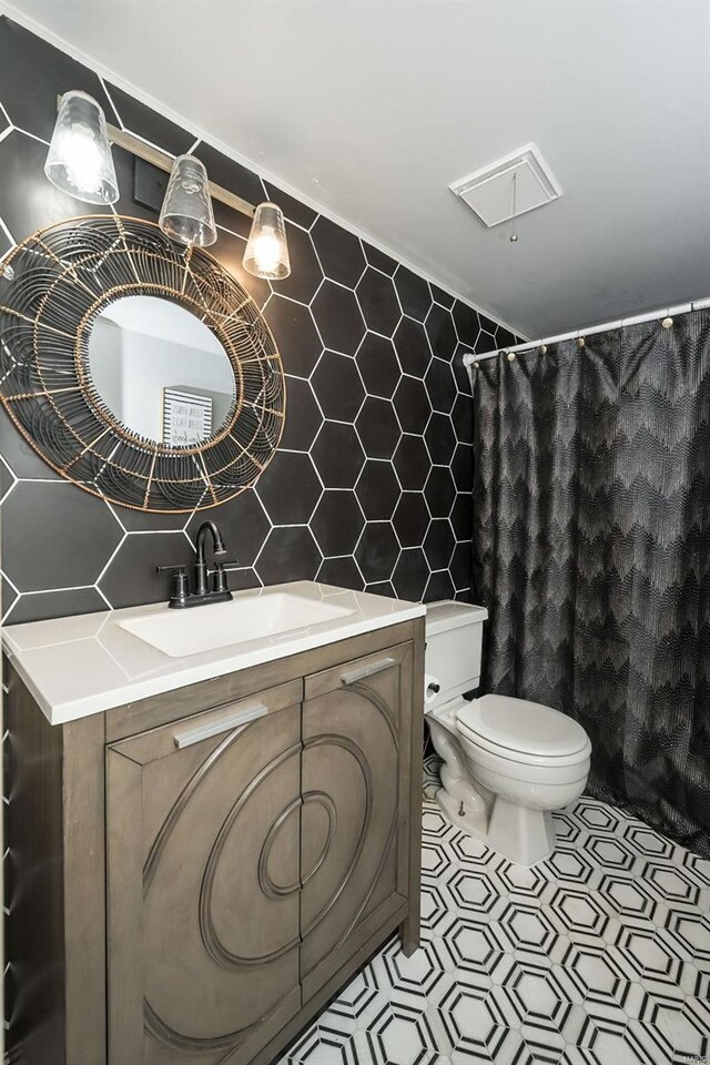 1523 S 10th St Unit 207, Saint Louis, MO 63101 - bathroom featuring tile walls, toilet, vanity, decorative backsplash, and a shower with curtain