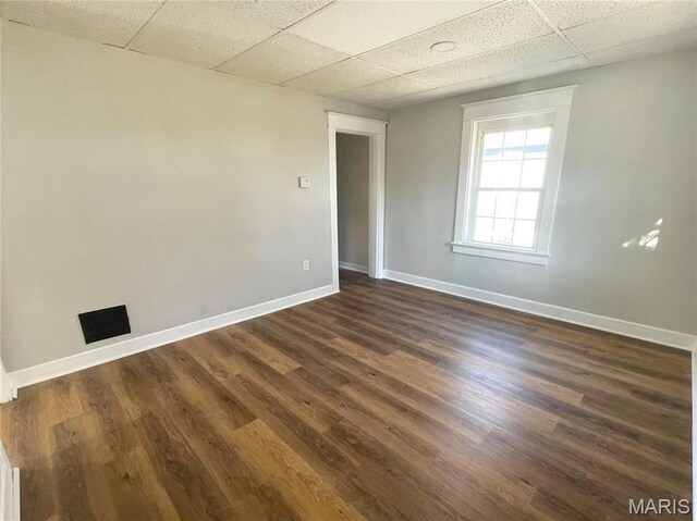 9411 Muriel Ave, Saint Louis, MO 63114 - spare room featuring a drop ceiling, baseboards, and dark wood-type flooring