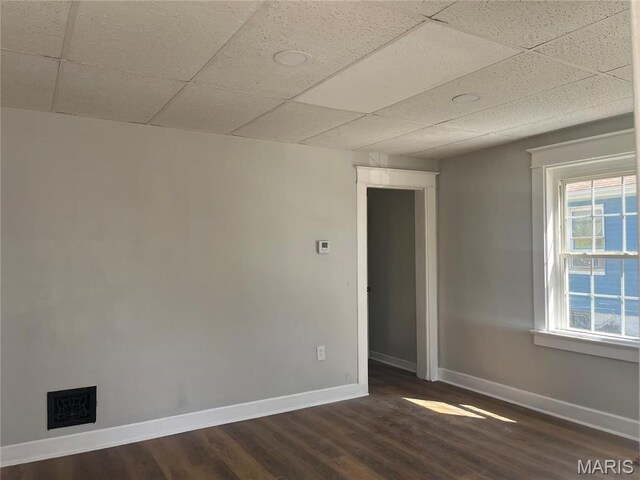 9411 Muriel Ave, Saint Louis, MO 63114 - empty room featuring baseboards, dark wood-style flooring, and a drop ceiling
