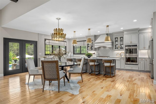 130 Foristell Ridge Ct, Foristell, MO 63348 - dining room with light wood-style flooring, recessed lighting, french doors, and a chandelier