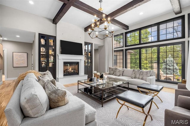 130 Foristell Ridge Ct, Foristell, MO 63348 - living area featuring wood finished floors, beam ceiling, a glass covered fireplace, a chandelier, and recessed lighting