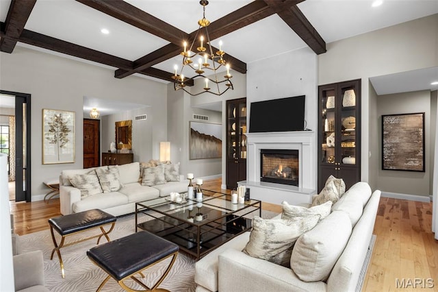 130 Foristell Ridge Ct, Foristell, MO 63348 - living room with coffered ceiling, a warm lit fireplace, wood finished floors, beamed ceiling, and a chandelier