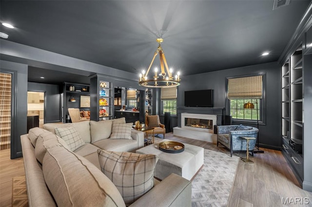 130 Foristell Ridge Ct, Foristell, MO 63348 - living area featuring a chandelier, a glass covered fireplace, wood finished floors, and recessed lighting