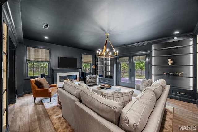 130 Foristell Ridge Ct, Foristell, MO 63348 - living area with a chandelier, plenty of natural light, a fireplace, french doors, and crown molding