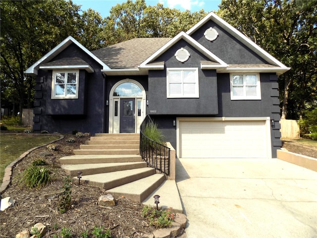 1002 Cypress Dr, Rolla, MO 65401 - bi-level home featuring an attached garage, stucco siding, driveway, and a shingled roof